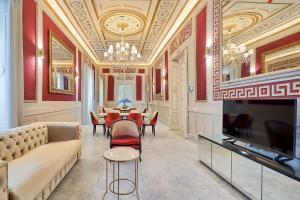 uma sala de estar com um sofá e uma televisão em Tandem Palacio Veedor de Galeras Suites em Cádiz