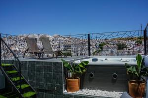 a hot tub on a balcony with a view of the beach at Hotel Posada de las Cuevas in Arcos de la Frontera