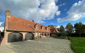 un bâtiment en briques avec deux portes de garage dans une allée. dans l'établissement La Maison Des Papillons, à Deerlijk