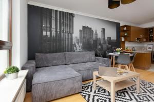 a living room with a couch and a table with a laptop at Apartments Warsaw Giełdowa 4 by Renters in Warsaw