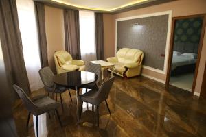 a hotel room with a table and chairs and a bed at Hotel Gold in Gyumri