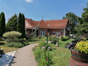 a house with a brick walkway in front of a yard at HARTMANN PANZIÓ in Barcs