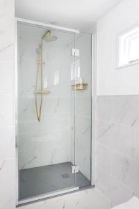 a shower with a glass door in a bathroom at The Queen's Inn in Hawkhurst