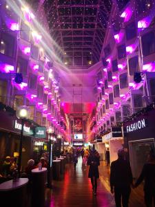 a shopping mall with purple lights and people walking in it at Tallink Silja Line Ferry - Helsinki to Stockholm in Helsinki