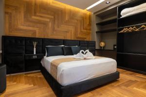 um quarto com uma cama grande e uma cabeceira preta em B&Z LUXURY em Bari