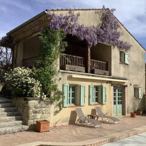een huis met een krans van paarse bloemen erop bij Courtyard Gite with very large shared pool in Castres