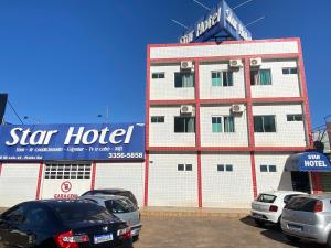 un hotel con coches aparcados delante en Star Hotel en Taguatinga