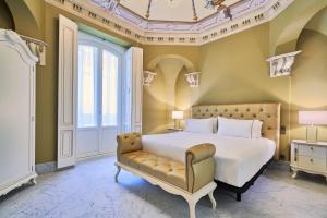 sypialnia z łóżkiem i kanapą w obiekcie Tandem Palacio Veedor de Galeras Suites w Kadyksie