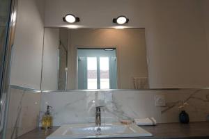 a bathroom with a sink and a large mirror at appartement MONTAIGNE in Bordeaux