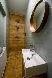 een badkamer met een witte wastafel en een spiegel bij Edelin Cottage in Edelény