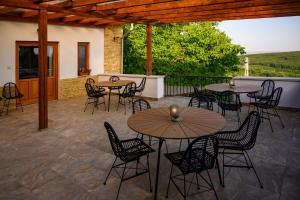 un patio con mesas y sillas en una terraza en Edelin Cottage, en Edelény