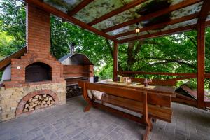 un patio con un horno de ladrillo y un banco de madera en Edelin Cottage, en Edelény