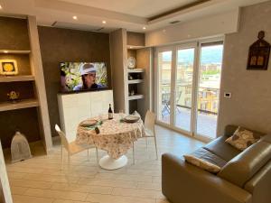 ein Wohnzimmer mit einem Tisch und einem TV in der Unterkunft Romantica Suite in Verbania