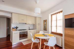 a kitchen with a table and chairs and a kitchen with white cabinets at Piccola Corte in Arco