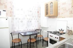 een keuken met een tafel en 4 stoelen en een fornuis bij Гоголя 14 а in Dnipro