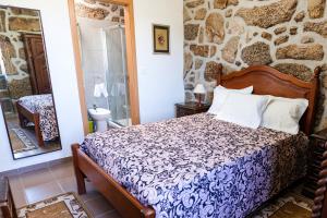 a bedroom with a bed and a stone wall at Idyllic Villa in Fornos + Pool! in Fornos +55 photos