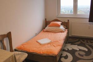 a small bed in a room with a window at Sunset-view Apartment in Debrecen