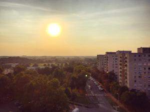 a view of a city with the sun in the sky at Sunset-view Apartment in Debrecen