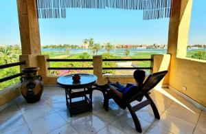 een kind in een stoel op een veranda met een tafel bij Nile Compound in Luxor