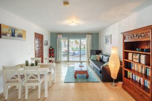 een woonkamer met een tafel en een bank bij Lanzahost Apartamento LARIMAR in Costa Teguise