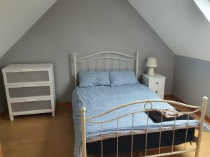 a bedroom with a bed with a blue comforter at Murphys Irish Farmhouse in Tralee