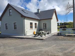 una casa bianca con un tavolo da picnic di fronte di Murphys Irish Farmhouse a Tralee