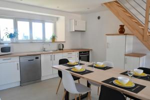a kitchen with a table and chairs in a kitchen at Aux champs Pressinois in Pressins