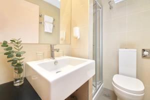 a white bathroom with a sink and a toilet at Hotel Zorna Plava Laguna in Poreč