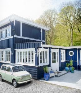 uma casa azul com um carro estacionado em frente em Hotel Villa Brinkly em Snekkersten