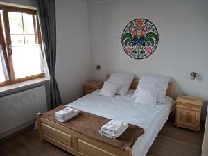 ein Schlafzimmer mit einem Bett mit zwei Handtüchern darauf in der Unterkunft Apartamenty Stajnia Ojcowizna in Pokrzywnica