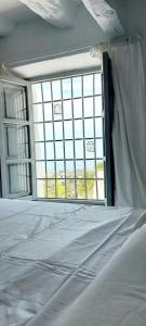 Bett in einem Zimmer mit einem großen Fenster in der Unterkunft Elysium - a romantic escape in Mojacar Pueblo in Mojácar