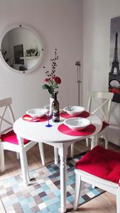 einen weißen Tisch und Stühle mit einem Tisch und einem Spiegel in der Unterkunft Feworeinhard in Speyer