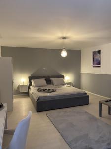 a bedroom with a large bed and a chair at Roomzzz Sibiu in Sibiu