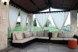 a couch sitting on a patio with white curtains at Panorama Siviris in Siviri