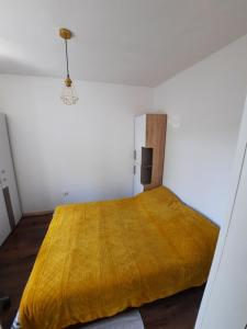 sypialnia z łóżkiem z żółtym kocem w obiekcie Apartament Zorzy przy Instytucie Kardiologii Anin w Warszawie