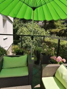 een groene parasol bovenop een patio bij apartman Fuerte 2 in Belgrado
