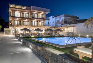 a hotel with a swimming pool in front of a building at Golden Bee Lifestyle in Stalida