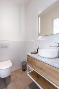 uma casa de banho branca com um lavatório e um WC em Singel 9 em Domburg