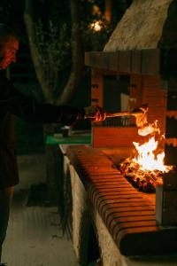 a man is cooking food in a brick oven at Calma Beach Hotel in Stavros