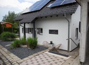 um edifício branco com painéis solares no telhado em Ferienhaus Pusteblume em Freyung