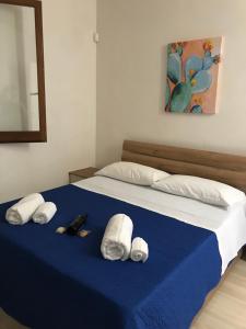 a bed with blue sheets and white towels on it at Case vacanze Spagnola 106 in Marsala