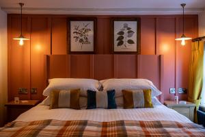 um quarto com uma cama grande e 2 almofadas em The Filly Inn em Brockenhurst
