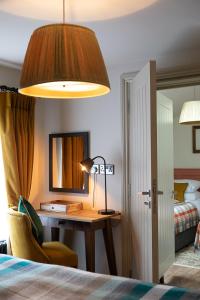 a bedroom with a desk with a lamp and a bed at The Filly Inn in Brockenhurst