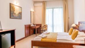 Postel nebo postele na pokoji v ubytování Hotel Tihany Átrium