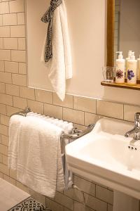 bagno bianco con lavandino e asciugamani di The Filly Inn a Brockenhurst