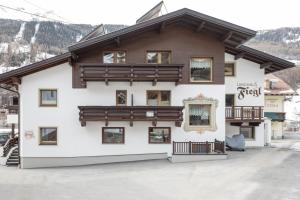 Un grand bâtiment blanc avec de nombreuses fenêtres dans l'établissement Landhaus Fiegl, à Sölden