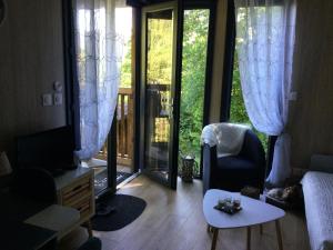 a living room with a couch and a tv and a table at Gîte le Pieraline in Ventron