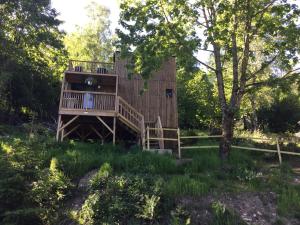 a tree house in the woods with a deck at Gîte le Pieraline in Ventron