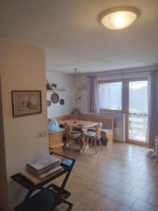 a living room with a table and a dining room at La casa di Grace nella valle incantantata in Carano