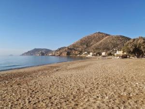 - une vue sur une plage avec des montagnes en arrière-plan dans l'établissement Beach Studio apartment 3, Komi, à Chios